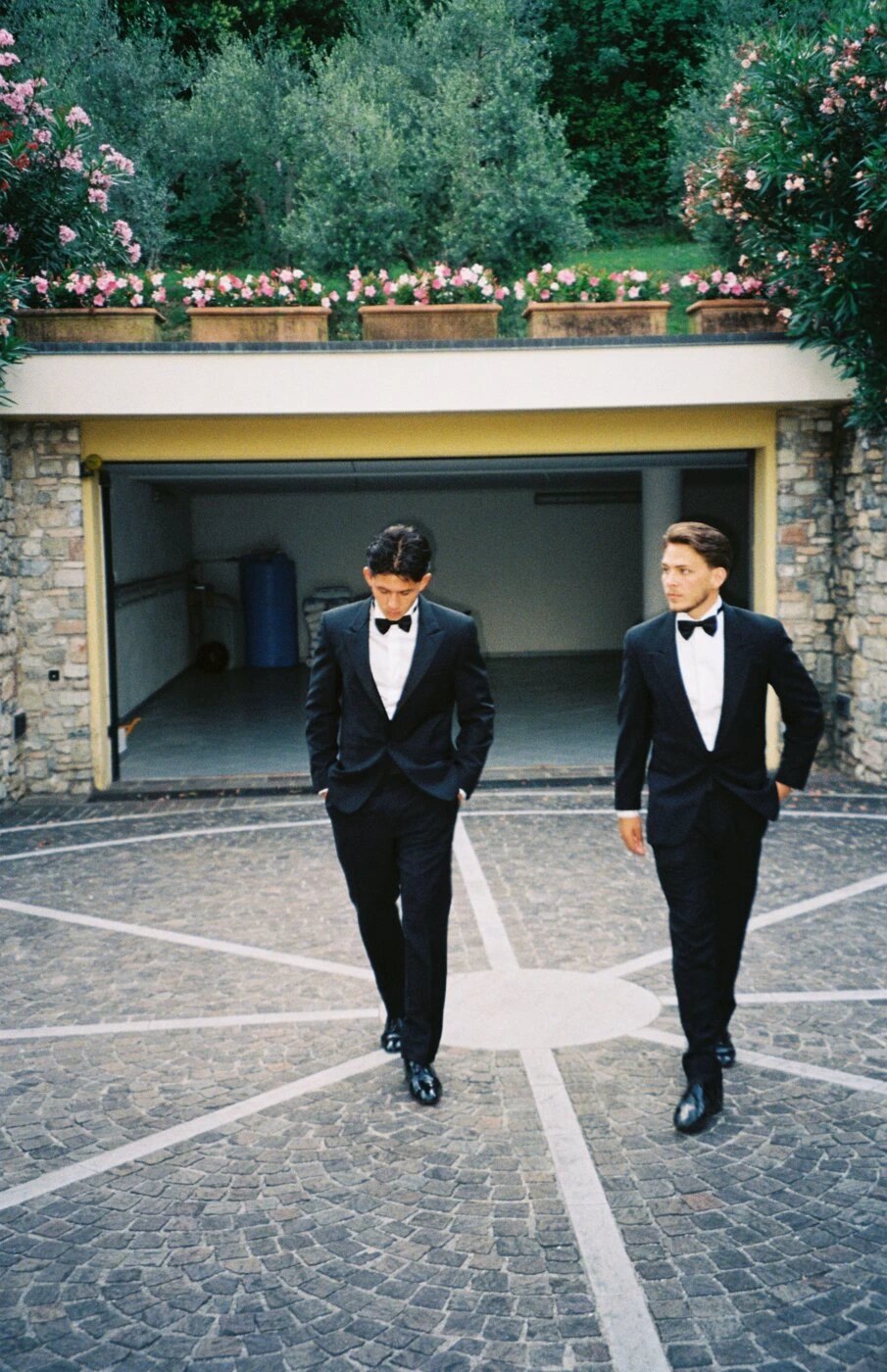 Two members in black tie crossing a courtyard